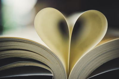Close-up of heart shape made from pages in book