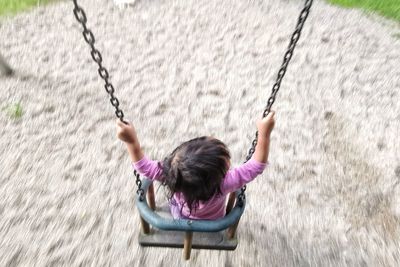 Rear view of woman sitting on swing at playground