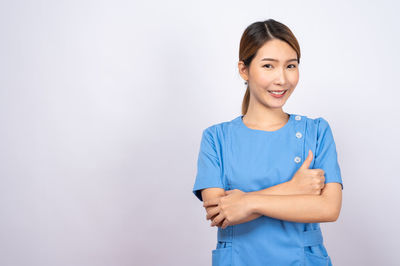 Portrait of a smiling young woman against white background