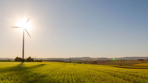 Scenic view of agricultural field with wind turbine on it, copy space