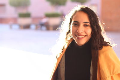 Portrait of smiling young woman in city