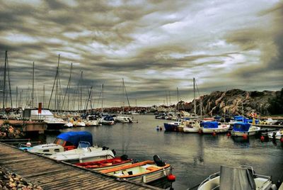 Boats moored at harbor against sky