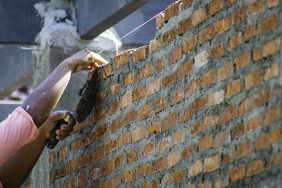 Cropped image of worker constructing wall