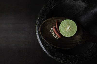 Directly above shot of ingredients in spoon over mortar and pestle on table