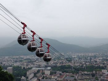 View of overhead cable cars in city against sky