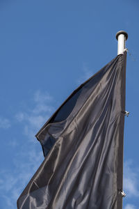 Low angle view of flag against blue sky