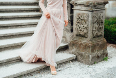 Low section of woman standing on staircase