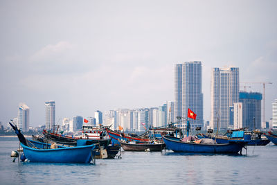 Selective focus on vietnamese flag on fishing boat moored in port against coast.