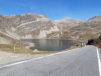 Road by mountains against sky