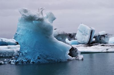 Frozen water in winter against sky