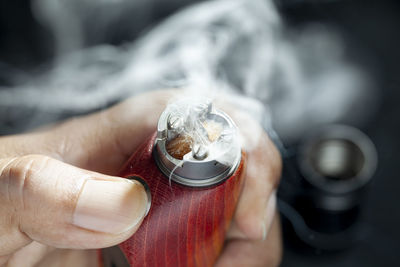 Close-up of hand holding cigarette