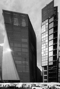 Low angle view of skyscrapers against cloudy sky