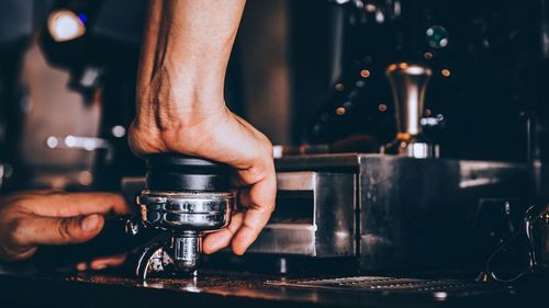 Man's hands with portafilter in coffee shop