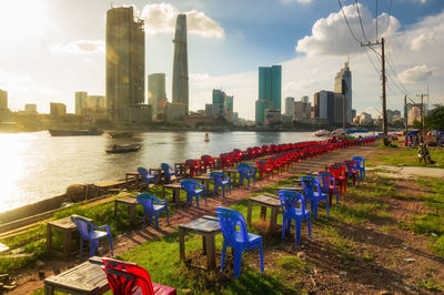 Modern buildings by river against sky in city