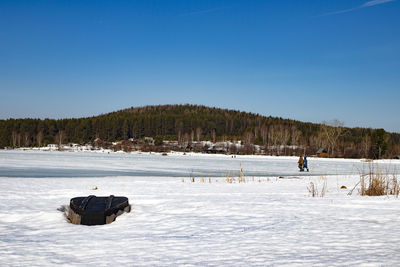 Scenic view of frozen lake against clear blue sky