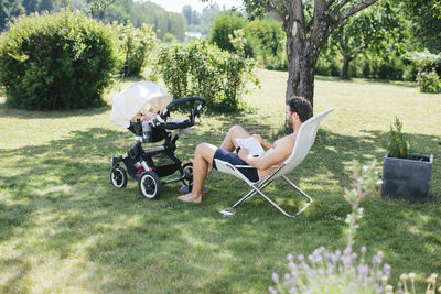 Father in garden with child in buggy