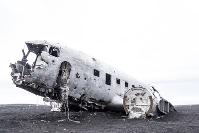 Abandoned airplane on land against sky