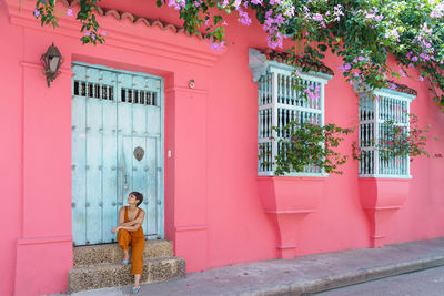 Rear view of woman standing against building