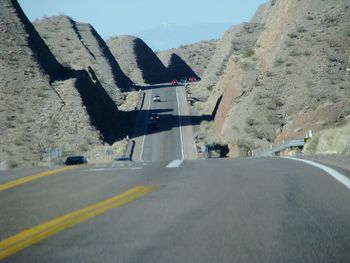 Road by mountain against sky