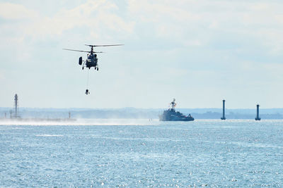 Battleship war ship corvette during naval exercises and helicopter maneuvering over baltic sea