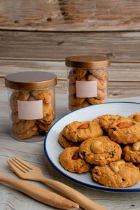 Homemade almond cookies in ceramic white plate on wood table background.