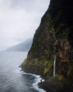 Scenic view of sea and mountains against sky
