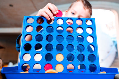 Close-up of boy playing with ball on table