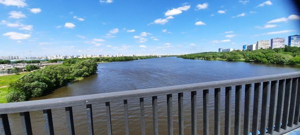 Scenic view of river by city against sky