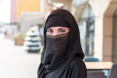 Young slender muslim woman in black clothes on the streets of dubai. person