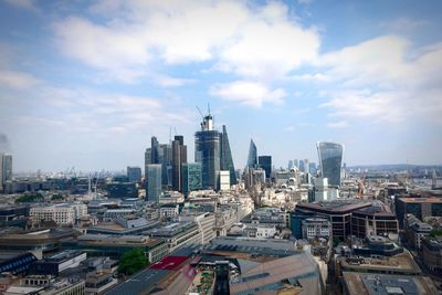 High angle view of city buildings against cloudy sky