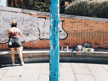 Rear view of woman standing by swimming pool