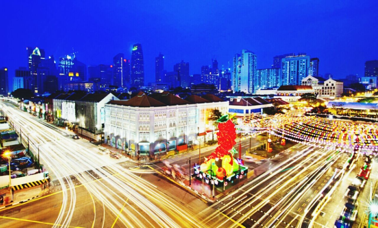 city, building exterior, architecture, built structure, transportation, high angle view, illuminated, cityscape, city life, skyscraper, clear sky, road, street, traffic, city street, light trail, modern, long exposure, night, blue