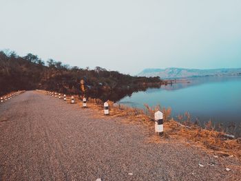 Rear view of people on lake against clear sky