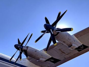 Low angle view of airplane against clear blue sky