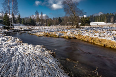 Scenic view of river against sky during winter