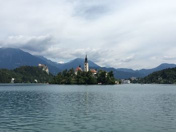 Scenic view of river and mountains against cloudy sky