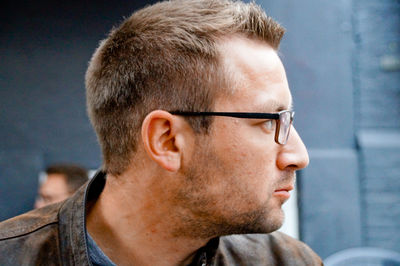 Close-up of young man wearing eyeglasses looking away in city
