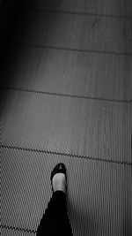 Low section of man standing on tiled floor