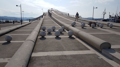 Street lights on bridge against sky