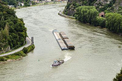 Two barges with a covered deck led by a tugboat on the rhine river in west germany,l.