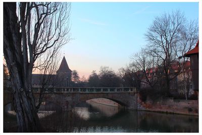 Arch bridge over river with city in background