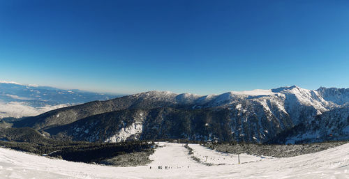 Scenic view of snowcapped mountains against clear sky