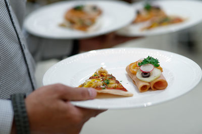 Close-up of man holding food in plate