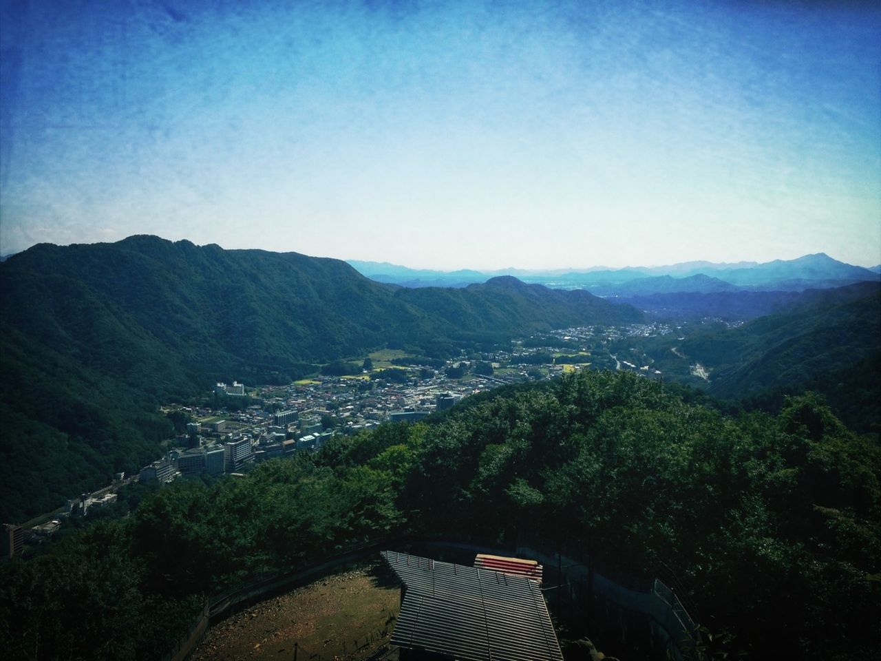 mountain, mountain range, high angle view, scenics, landscape, blue, clear sky, beauty in nature, tree, sky, tranquil scene, tranquility, copy space, nature, sunlight, built structure, building exterior, outdoors, day, architecture