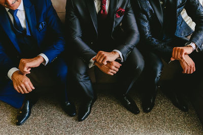 Low section of people sitting on floor