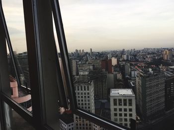 Cityscape against sky seen through glass window