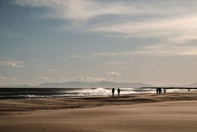 People on beach against sky