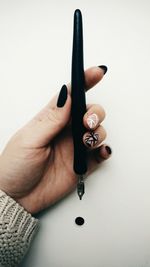 Close-up of woman holding hand over white background