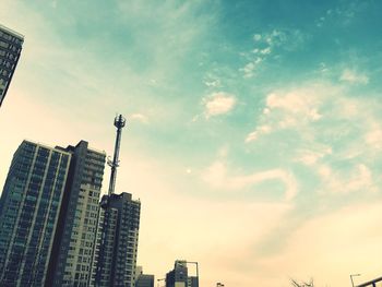 Low angle view of modern building against cloudy sky