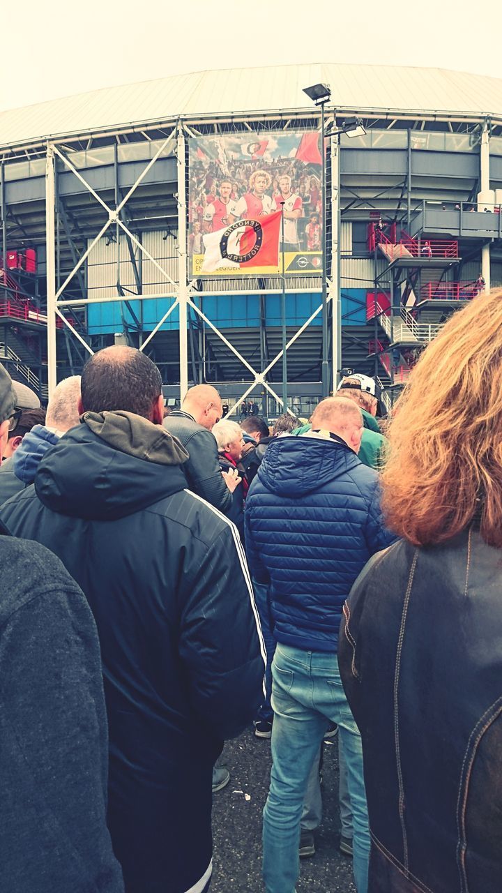 REAR VIEW OF PEOPLE WITH UMBRELLAS IN FOREGROUND